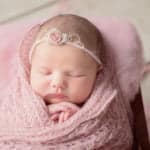 צילום ניובורן לתינוקת עטופה בורוד עם סרט ראש ורוד