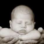 צילום ניובורן בשחור לבן של תינוק מוחזק על ידי הוריו