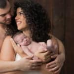 צילום ניובורן לתינוק עם ההורים על רקע עץ