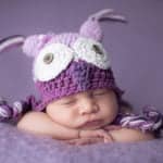 תינוקת ישנה בצילומי ניובורן עם כובע ינשוף סגול