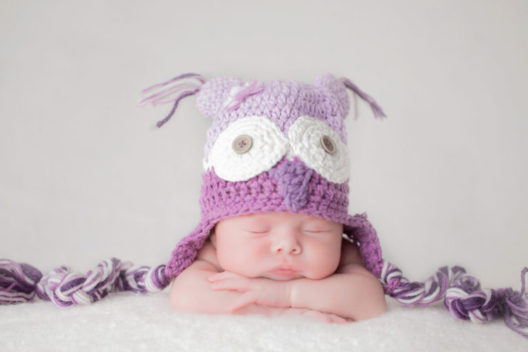 תינוקת מצולמת עם כובע ינשוף סגול