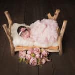 תמונה של תינוקת על מיטת עץ מיוחדת לצילומי ניו בורן