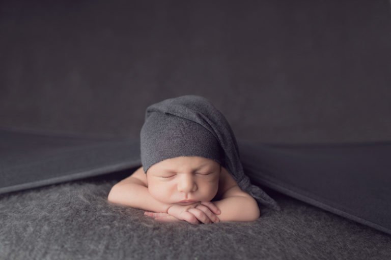 צילום ניובורן לתינוק שרק נולד עם כובע אפור