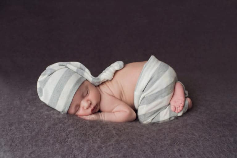 צילום ניובורן לתינוק עם מכנס אפור וכובע אפור