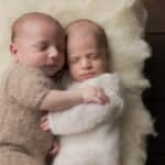 תינוק ותינוקת שרק נולדו מחבקים אחד את השניה במהלך צילומי ניו בורן