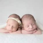 תינוק ותינוקת שרק נולדו בצילומי ניובורן על רקע לבן