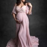 צילום הריון לאתי בשמלה ורודה על רקע אפור