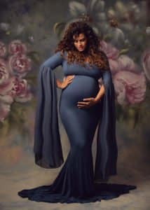 צילומי הריון לשירן עם שמלה כחולה ורקע פרחוני
